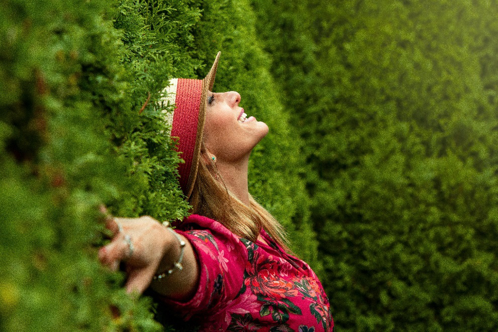 Woman in a red hat and suit lying on grass