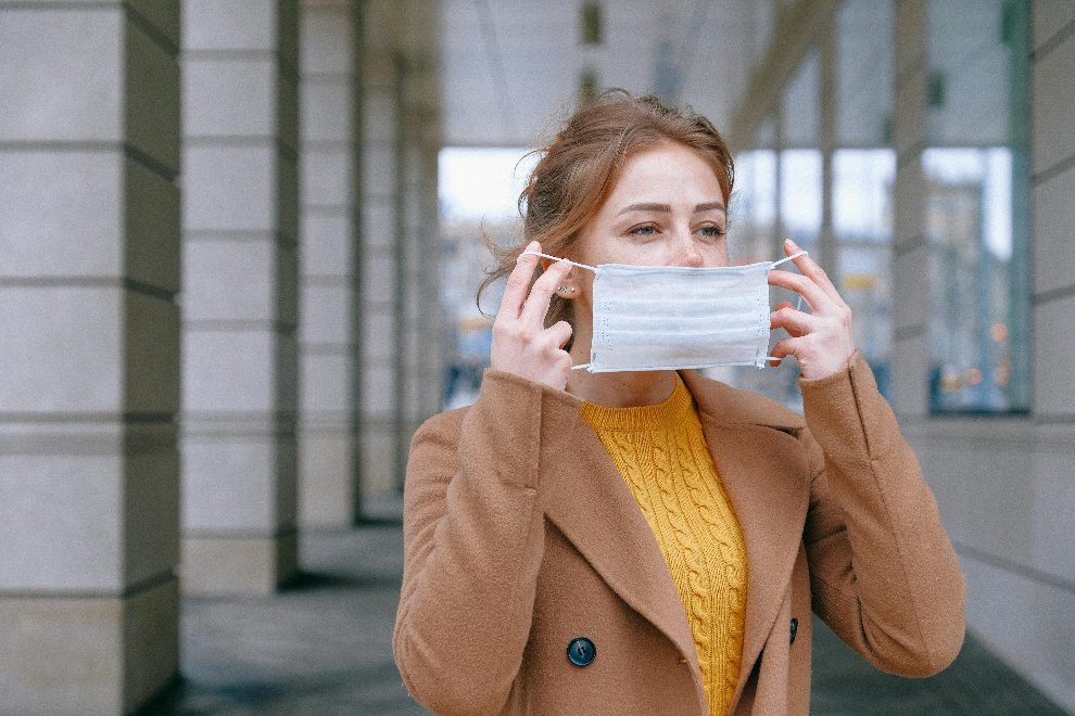 Woman with flu symptoms covering her face with a mask 