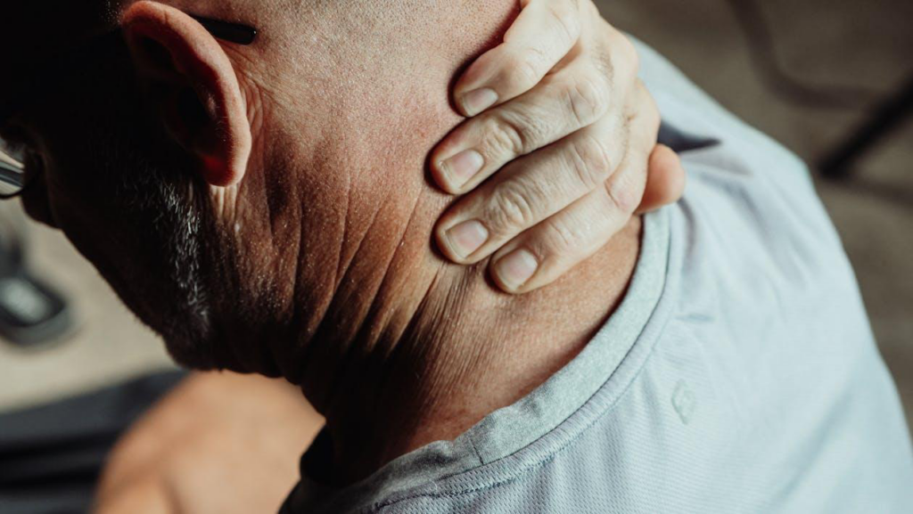 Close-up of a man holding his neck