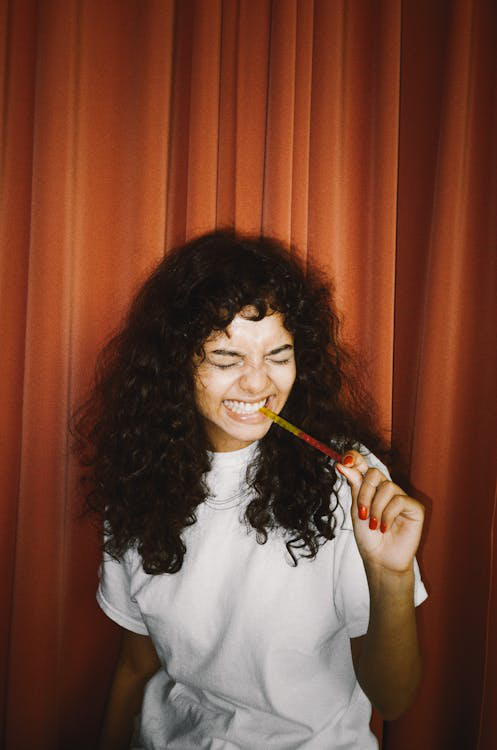  a woman eating a gummy.