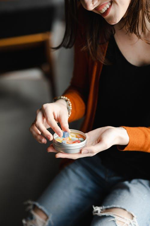 A woman holding CBD gummies in her hand