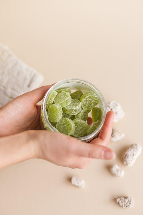 Close-up of a hand holding green gummies