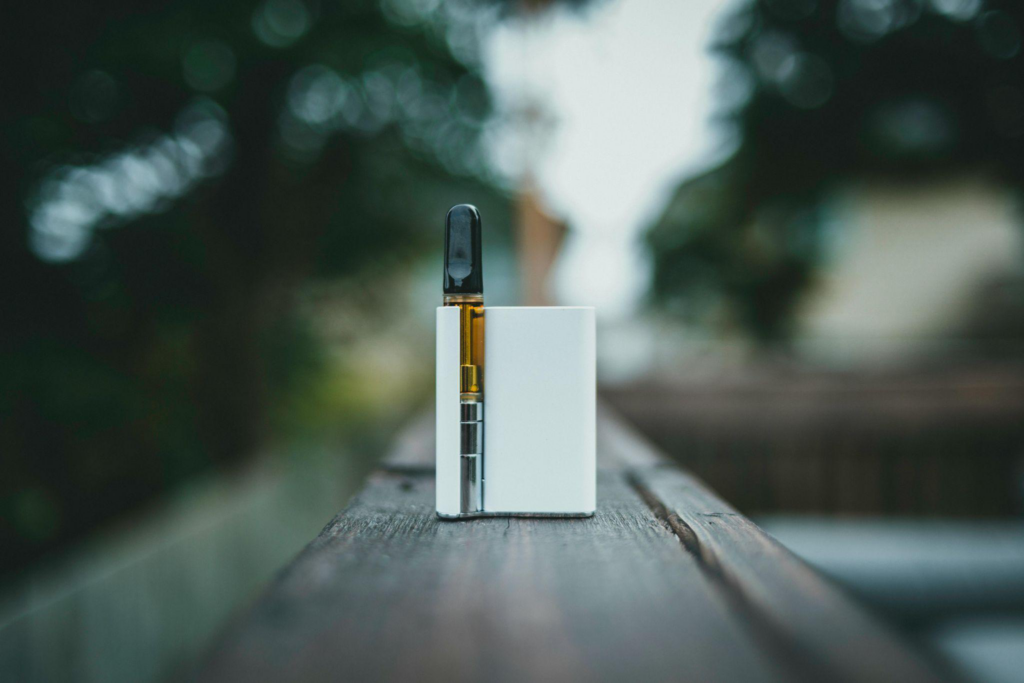 Small vape device against a tranquil outdoor backdrop symbolizing simplicity.