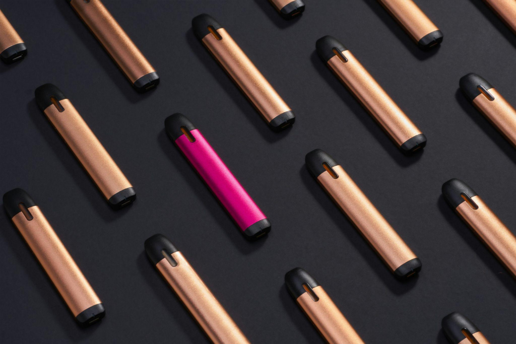  Pink vape pen focused amongst other vape pens. 