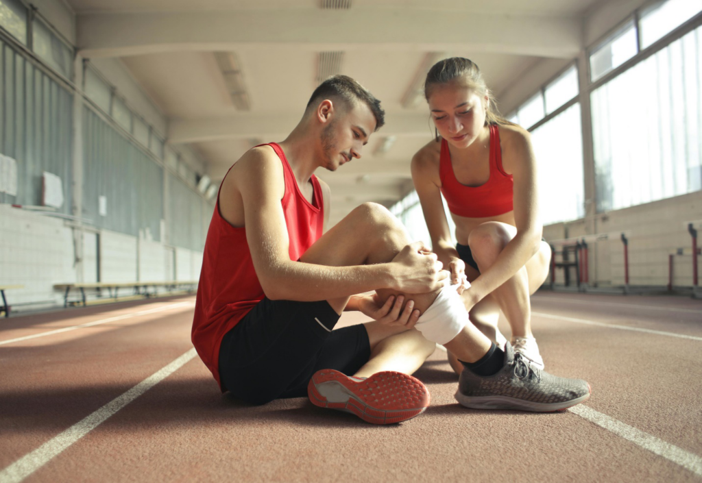 A picture of a person putting a bandage on another person’s leg