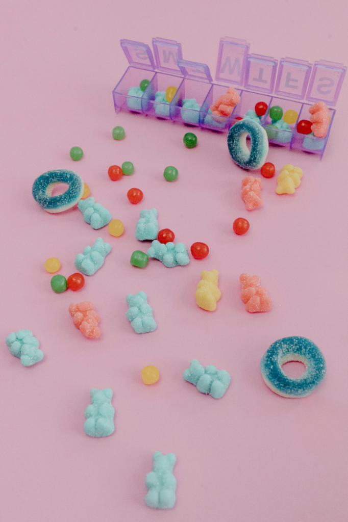 A picture of gummies placed against a pink background