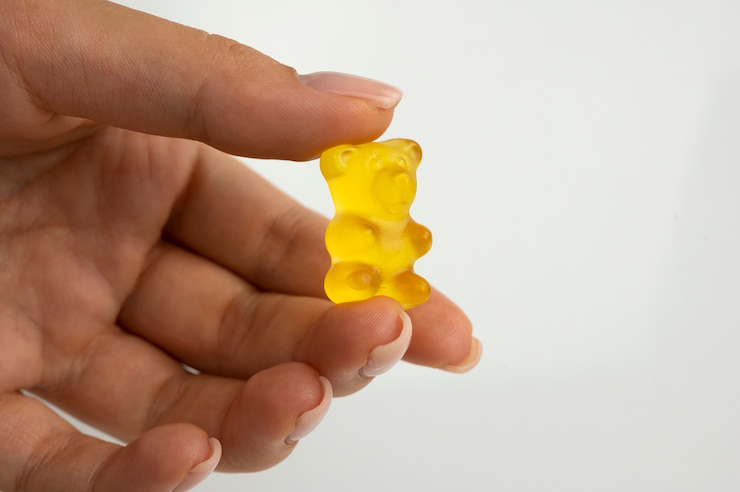 A person using CBD gummies to relieve bloating and discomfort