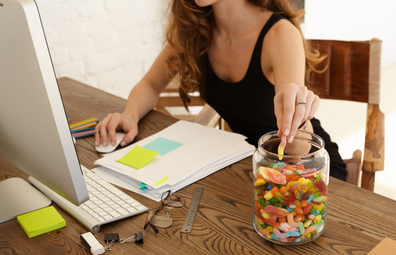 A picture of a person eating gummies during work