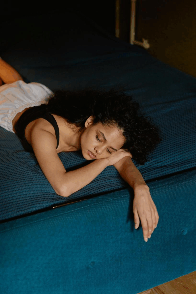 A picture of a sad person lying on a bed