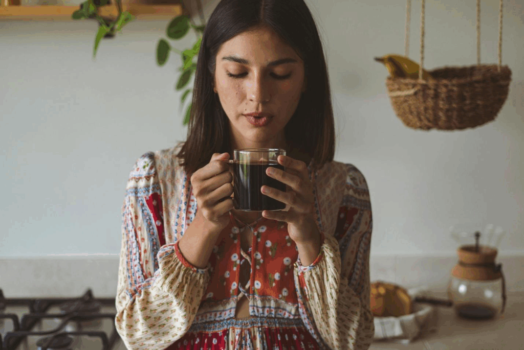 A picture of a person blowing on a coffee mug