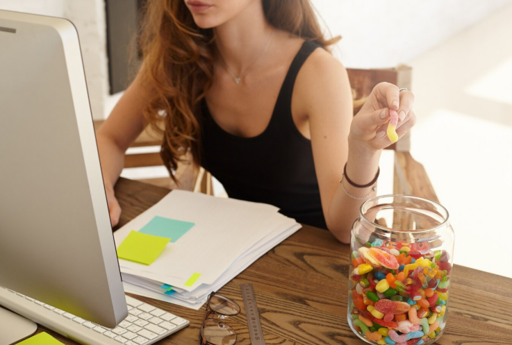 A picture of a person eating gummies during work