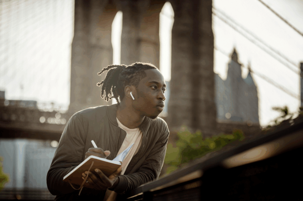 A picture of a person writing in their journal and standing outdoor