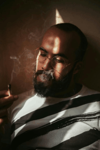 Man wearing glasses with calm expression.