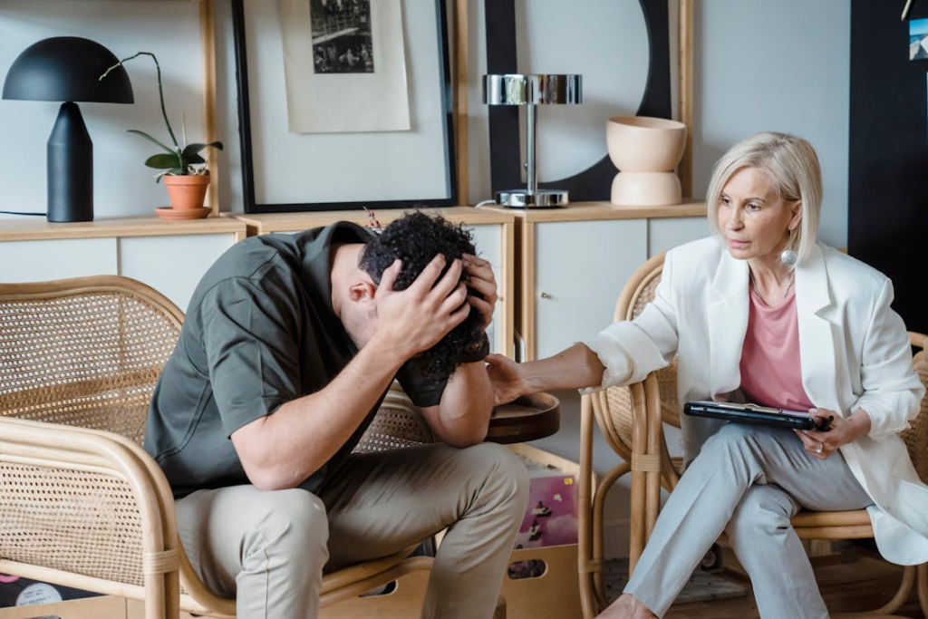 Woman speaking supportively with a man who appears emotionally distressed