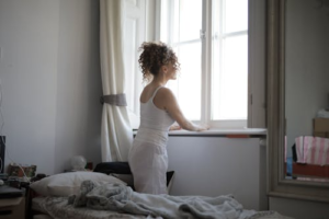 calm woman in sleepwear on bed at home