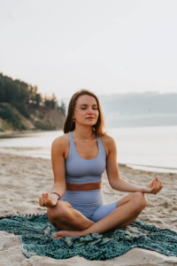 A woman is doing yoga near the seashore