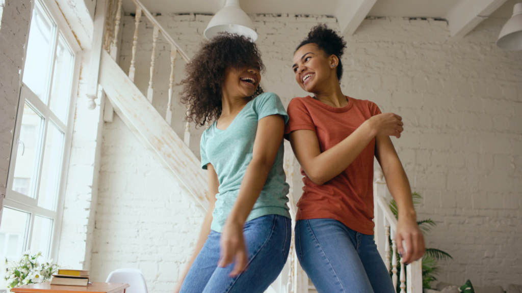 Two people enjoying a lighthearted moment together in a bright indoor space
