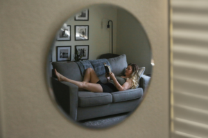 Person relaxing on a couch during a quiet and low-stimulation evening at home