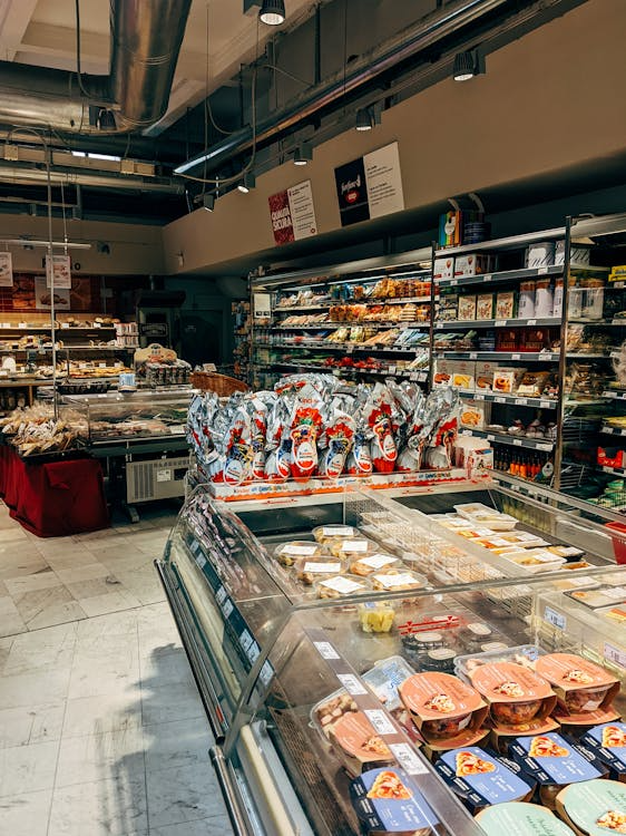 A well-organized supermarket aisle with shelves of various packaged goods, snacks, and consumer products neatly arranged for display.
