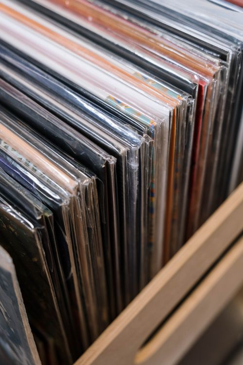 A close-up view of vinyl records arranged on shelves in a record shop or personal collection.