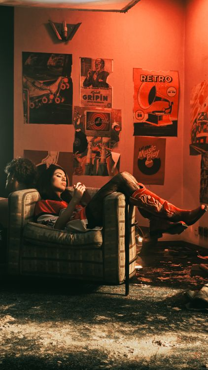 A cozy retro-style room with warm red lighting, vintage posters, and personal styling expressing cultural identity.