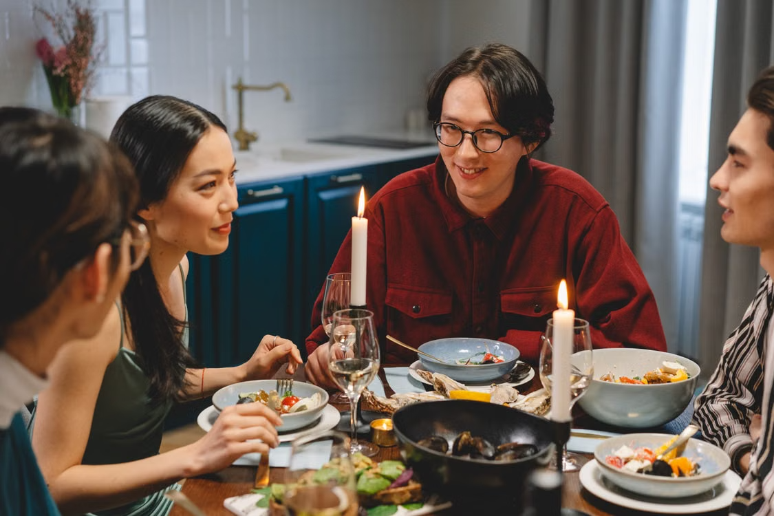 Four friends talking around kitchen table
