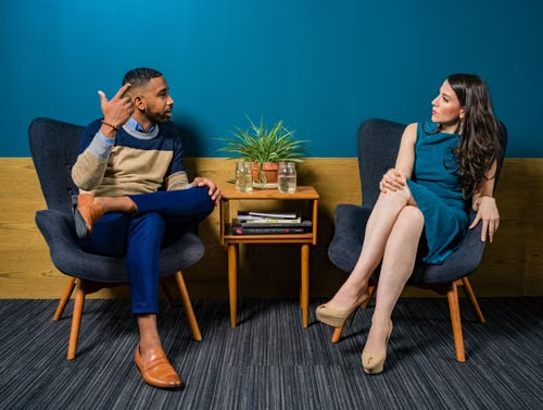 Two people talking in corner
