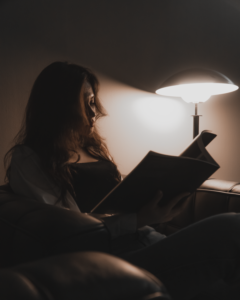 Person reading alone under lamp