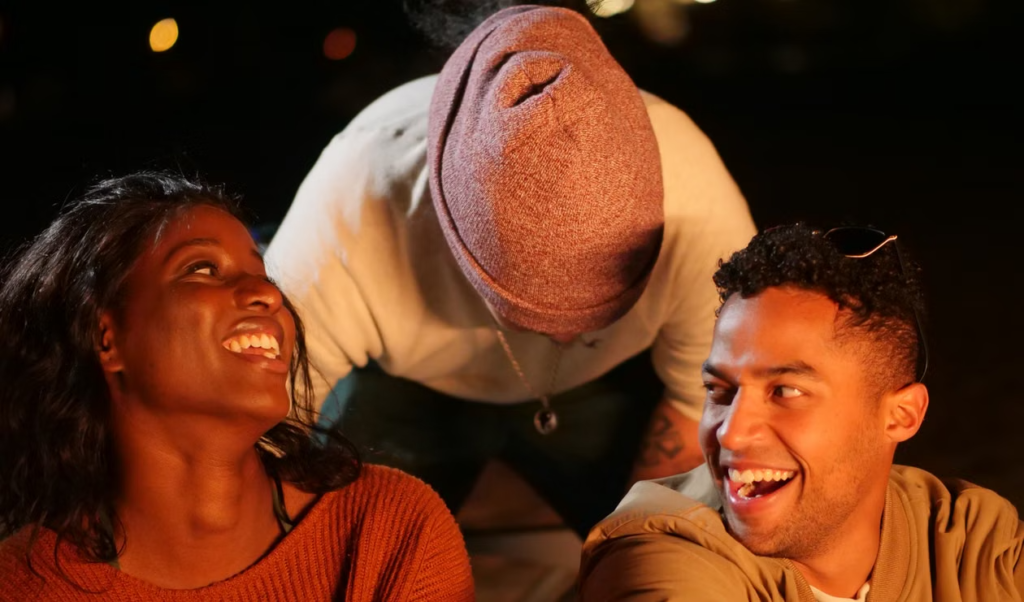 A group of friends laughing together while relaxing indoors during a casual get-together