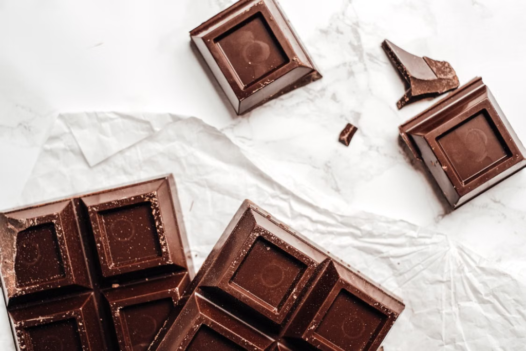 Neatly arranged cannabis digital art chocolate edibles on white paper, ready to share