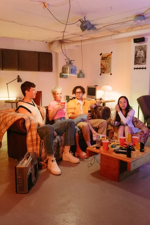 A group of friends sitting together in a living room enjoying a relaxed evening at home