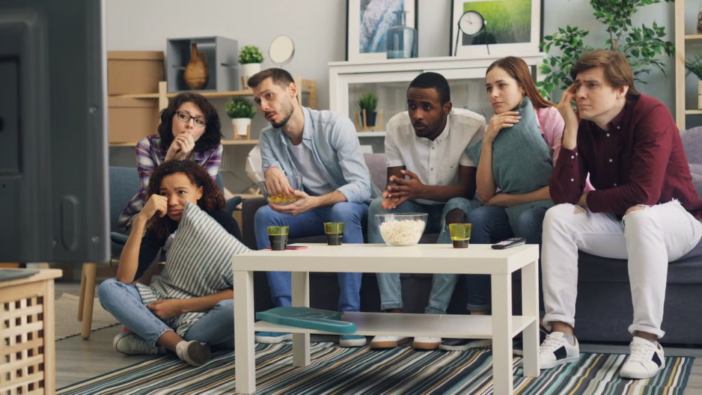  A group of people sitting together on a couch in a living room, relaxed and chatting